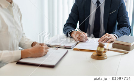law concept The legal practitioner reading an official document that his advisee, the man in white long sleeved shirt hand to him and writing the signature on it 83997714