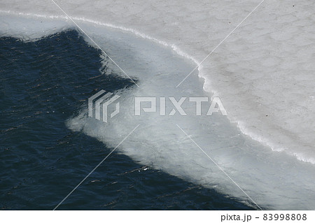 凍っている池が少しずつ溶けていく鬼面川貯水池 83998808