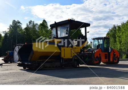Asphalt paver machine during road work. Asphalt paver machine during road work. 84001588