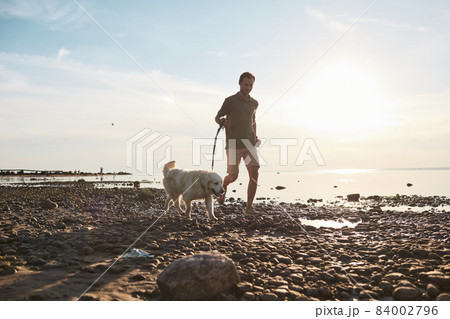Man Running by Lake with Dog 84002796