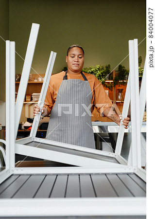 Woman Turning Tables Over Woman Turning Tables Over 84004077