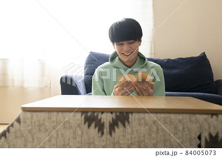 こたつで読書をする男子学生 84005073