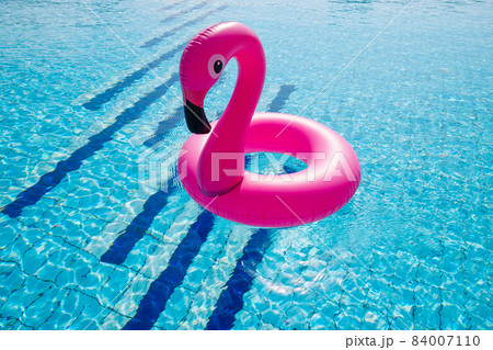 Flamingo plastic. Pink inflatable flamingo in pool water for beach background. Trendy summer concept. Flamingo plastic. Pink inflatable flamingo in pool water for beach background. Trendy summer concept. 84007110