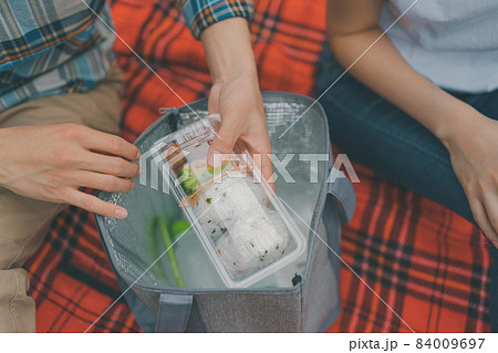 手作り弁当を持参してピクニックするカップル 手作り弁当を持参してピクニックするカップル 84009697