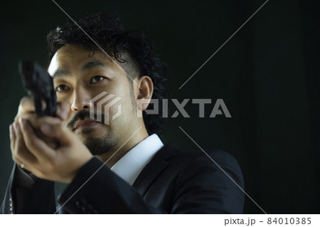 モデルガンで遊ぶヒゲの人 84010385