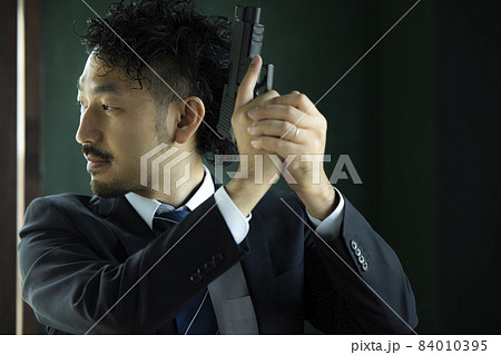 モデルガンで遊ぶヒゲの人 84010395
