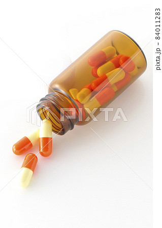 小瓶とカプセル剤を白背景で撮影 84011283