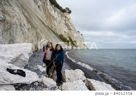 A mother and daughter with a dog in front of a beautiful chalk cliff A mother and daughter with a dog in front of a beautiful chalk cliff 84012556