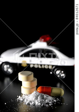 パトカーの模型と薬を黒背景で撮影 84012671