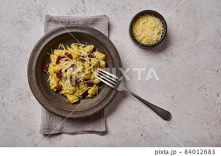 Traditional Mediterranean and Alpine potato gnocchi with parmesan and dried tomatoes in ceramic Traditional Mediterranean and Alpine potato gnocchi with parmesan and dried tomatoes in ceramic 84012683