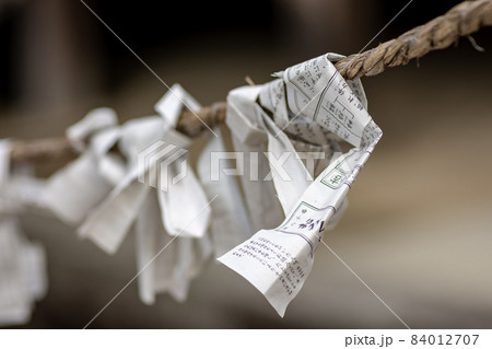 Omikuji fortunes written on strips of paper at Buddhist temple in Nara, Japan 84012707