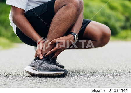 sport runner man use hands joint hold leg pain because of twisted ankle broken while running 84014595