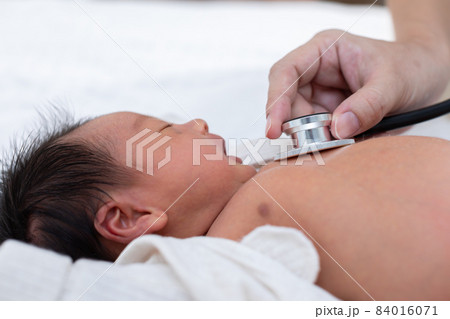 Unrecognizable Doctor heart check up and diagnosis baby newborn with stethoscope in clinic or hospital.Examining heartbeat of infant with stethoscope on chest sick baby.Baby Health Care Concept 84016071