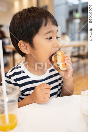 フードコートでハンバーガーを食べる4歳男児 フードコートでハンバーガーを食べる4歳男児 84016974