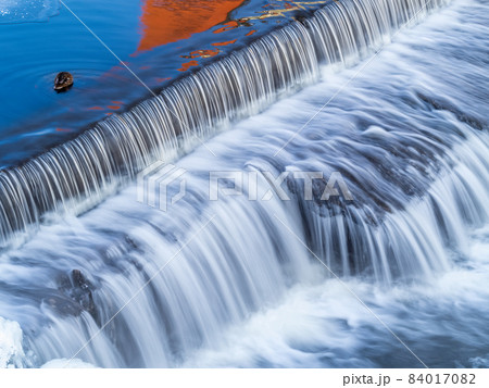A small flat cascade in a calm river A small flat cascade in a calm river 84017082