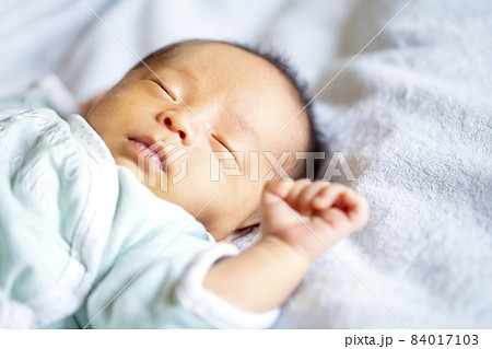 生後2週間の赤ちゃんの寝顔の写真素材