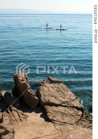 View from Icici's seaside promenade, the rocky beach with surfers,Adriatic coast, Kvarner bay, city details, Croatia 84019583
