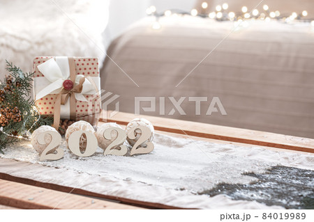 Christmas composition with numbers 2022 on blurred background with bokeh. Christmas composition with numbers 2022 on blurred background with bokeh. 84019989