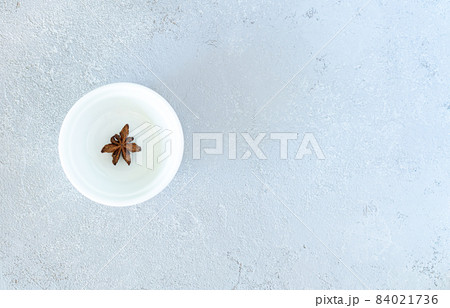 Anise on a white plate, on a gray background Anise on a white plate, on a gray background 84021736
