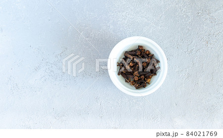 Dry cloves spices in white plate isolated on gray background 84021769