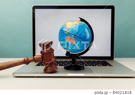 Wooden judge gavel and globe on laptop. International law concept 84021818