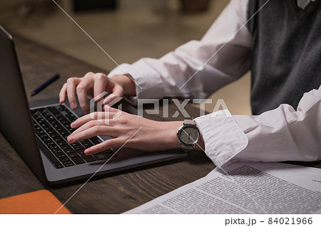 Close-up of office worker sitting at her workplace and typing document on laptop at office Close-up of office worker sitting at her workplace and typing document on laptop at office 84021966