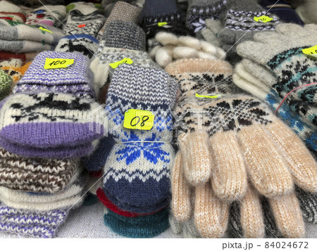 woven gloves and socks at a market with price labels 84024672