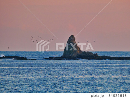 赤い空と青い海が鮮やかな茅ヶ崎サザンビーチ烏帽子岩の夕景　ウミウの寝城になっているようです 84025613