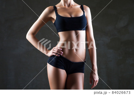 Slim woman's body over dark grey background 84026673