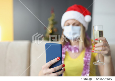Woman in face mask record video congratulation for family with glass of champagne 84027485