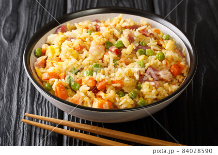 Traditional fried Chinese rice with vegetables, eggs, shrimps, pork close-up in a bowl. horizontal Traditional fried Chinese rice with vegetables, eggs, shrimps, pork close-up in a bowl. horizontal 84028590