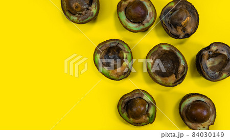 Ugly food on yellow background. Rotten tropical Avocado fruits. Concept of rotten fruit. Copy space on yellow background. 84030149