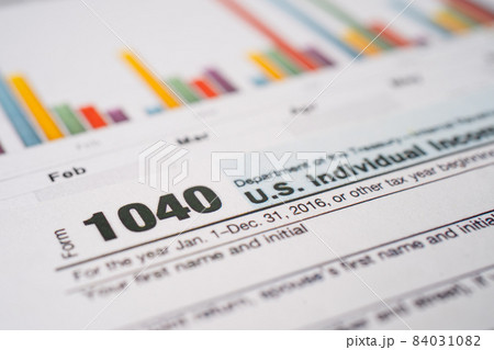 Bangkok, Thailand - June 1, 2020 Tax Return form 1040 and dollar banknote, U.S. Individual Income. Bangkok, Thailand - June 1, 2020 Tax Return form 1040 and dollar banknote, U.S. Individual Income. 84031082