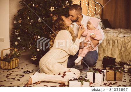 Kissing parents and baby at xmas. Kissing parents and baby at xmas. 84031697