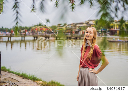 Woman tourist on background of Hoi An ancient town, Vietnam. Vietnam opens to tourists again after quarantine Coronovirus COVID 19 Woman tourist on background of Hoi An ancient town, Vietnam. Vietnam opens to tourists again after quarantine Coronovirus COVID 19 84031917