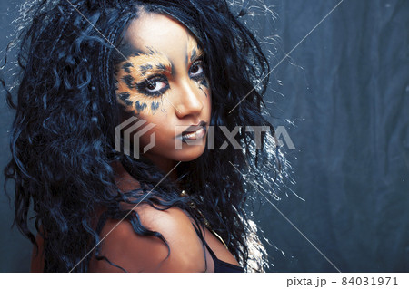 beauty afro girl with cat make up, creative leopard print on face closeup halloween woman 84031971