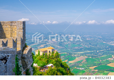 Aerial top panoramic view of Basilica Pieve, Palazzo Pubblico palace and landscape with valley 84032383