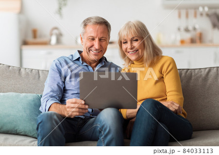 Happy Mature Couple Using Laptop Browsing Internet Together At Home Happy Mature Couple Using Laptop Browsing Internet Together At Home 84033113