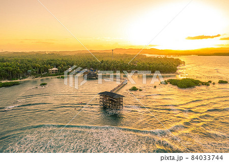 Aerial shot a sunset on wooden building in the middle of the waters of General Luna, Siargao Island 84033744
