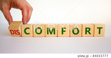 From discomfort to comfort symbol. Psychologist turns a cube and changes the word 'discomfort' to 'comfort'. Beautiful white background, copy space. Business, discomfort or comfort concept. From discomfort to comfort symbol. Psychologist turns a cube and changes the word 'discomfort' to 'comfort'. Beautiful white background, copy space. Business, discomfort or comfort concept. 84033777