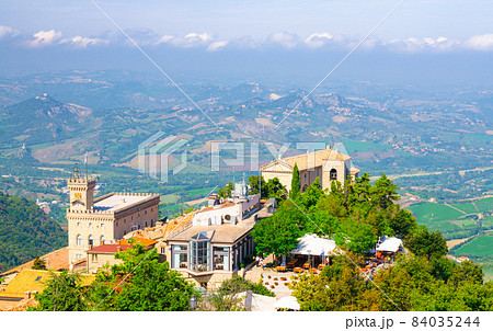 Aerial top panoramic view of Basilica, Palazzo Pubblico palace and landscape with valley Aerial top panoramic view of Basilica, Palazzo Pubblico palace and landscape with valley 84035244