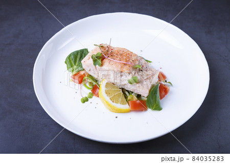 Trout (salmon) with vegetables, lemon and microgreens, cooked by the confit method. Traditional French dish. Step by step. Close-up. Trout (salmon) with vegetables, lemon and microgreens, cooked by the confit method. Traditional French dish. Step by step. Close-up. 84035283