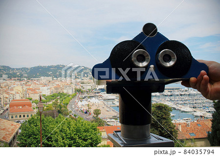 Man's hand holding a telescope ready to observe the city landscape Man's hand holding a telescope ready to observe the city landscape 84035794