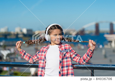Happiness is for now. Little girl listen to music outdoor.  84036706