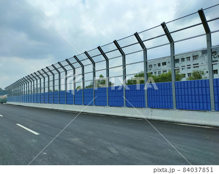SELANGOR, MALAYSIA - JULY 5, 2020: Noise barriers are installed along the vehicle lane bordering the residence to prevent noise pollution to the surrounding locals. SELANGOR, MALAYSIA - JULY 5, 2020: Noise barriers are installed along the vehicle lane bordering the residence to prevent noise pollution to the surrounding locals. 84037851