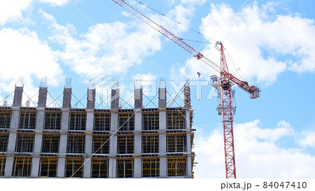 construction crane and unfinished residential buildings against the backdrop of blue sky and construction crane and unfinished residential buildings against the backdrop of blue sky and 84047410