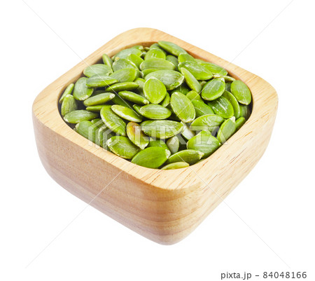Pumpkin seeds green peeled in wooden bowl isolated on white background. 84048166