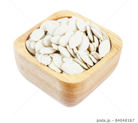 Pumpkin seeds unpeeled in wooden bowl isolated on white background. Pumpkin seeds unpeeled in wooden bowl isolated on white background. 84048167