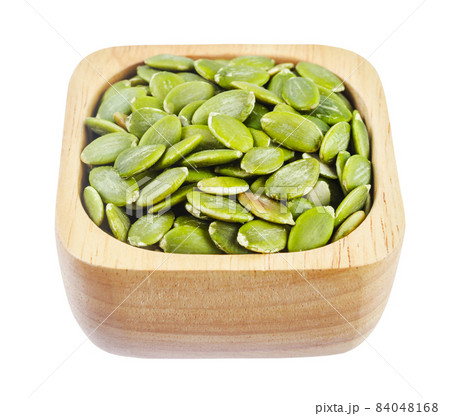 Pumpkin seeds green peeled in wooden bowl isolated on white background. 84048168