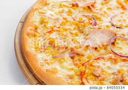 Pizza with chicken, paprika and corn. Italian kitchen and cooking concept. Chief with a pizza cutter cutting pizza to pieces at Neapolitan pizzeria. 84050334